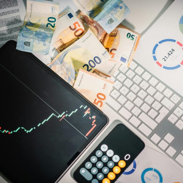 pexels-photo-26743048-26743048 Overhead view of financial tools with Euro banknotes on a desk showing market trends and graphs.